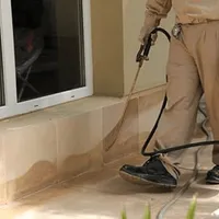 General pest control technician spraying exterior perimeter around a home in Chattanooga, TN