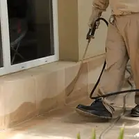 General pest control technician spraying exterior perimeter around a home in Chattanooga, TN